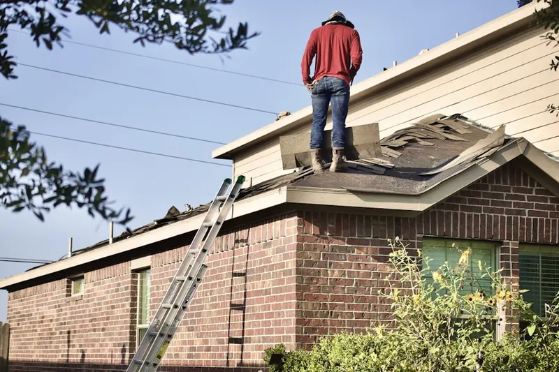 Professional roofer working on a residential roof in Roggen